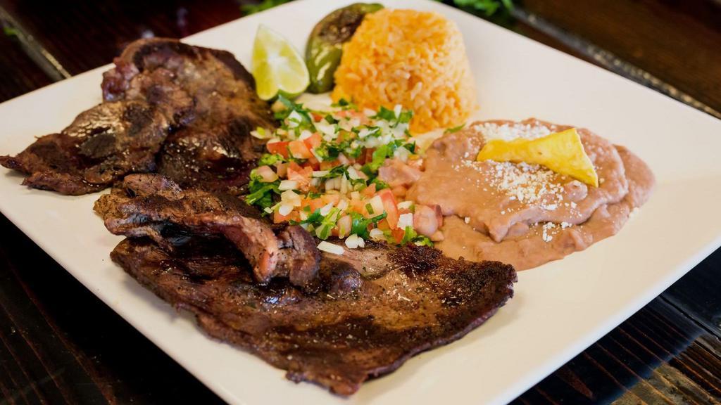 Carne Asada · Grilled steak with beans topped with cotija cheese, rice, pico de gallo and choice  corn or flour tortillas.
(Carne Asada con arroz frijoles y pico de gallo con tortillas de maiz o harina).