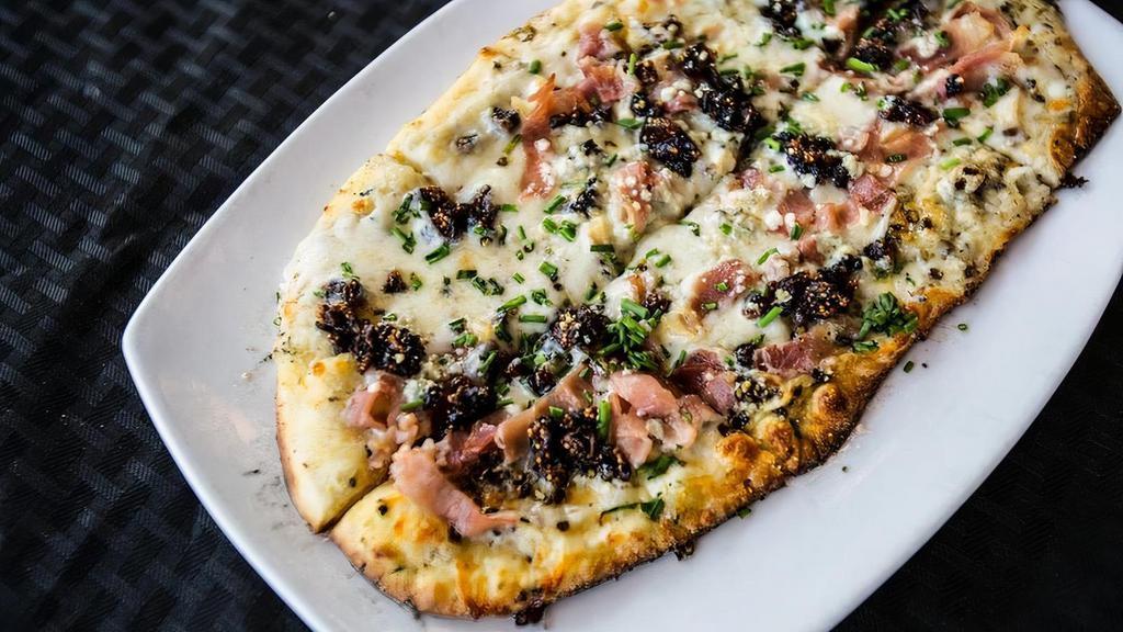 Fig And Proscuitto Flat · Gorgonzola, black Mission figs, black pepper, prosciutto, chives.