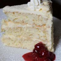 Togo White Coconut Cake · Three layers of rich, dense yellow cake, toasted coconut, white chocolate chips and frosted ...