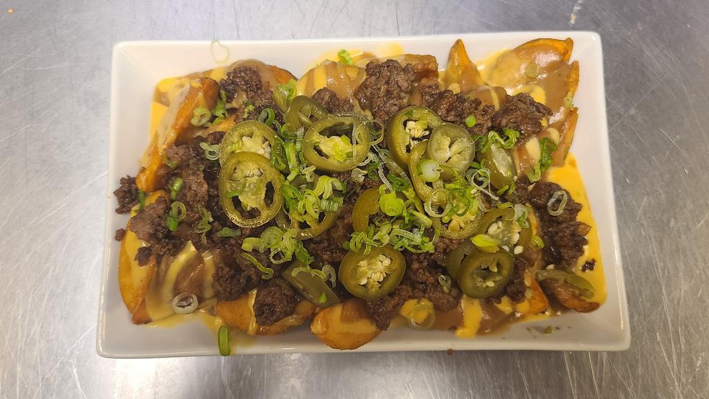 Junkyard Fries · Steak fries with bulgogi gravy, house made beer cheese topped off with bulgogi, green onions and pickled jalapenos