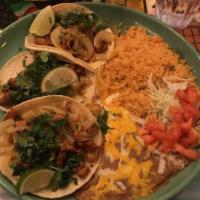 Tacos Al Pastor · Three thick corn tortillas stuffed with diced pork that has been marinated in a blend of pin...