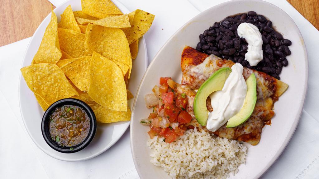 Cheese Enchilada · Two Jack cheese enchiladas topped with house made guajillo red sauce. Topped with sliced avocado, pico de gallo and crema agria. Served with black beans, minted rice, a handful of chips and a side of salsa.