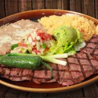 Carne Asada · Grilled skirt steak topped with sautéed onions, tomatoes, and jalapeño pepper. Served with r...