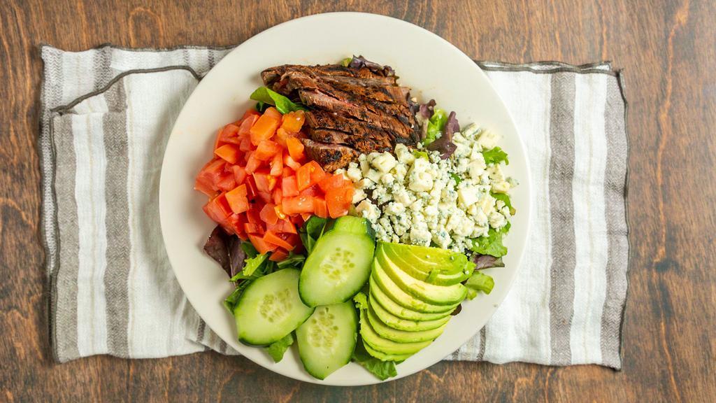 Black And Bleu Steak Salad · Gluten Free. Blacked marinated flank steak cooked to your specifications, served on a mixed green salad topped with diced tomatoes, blue cheese crumbles, cucumbers, avocado and Bleu cheese dressing. Served with a roll and butter.