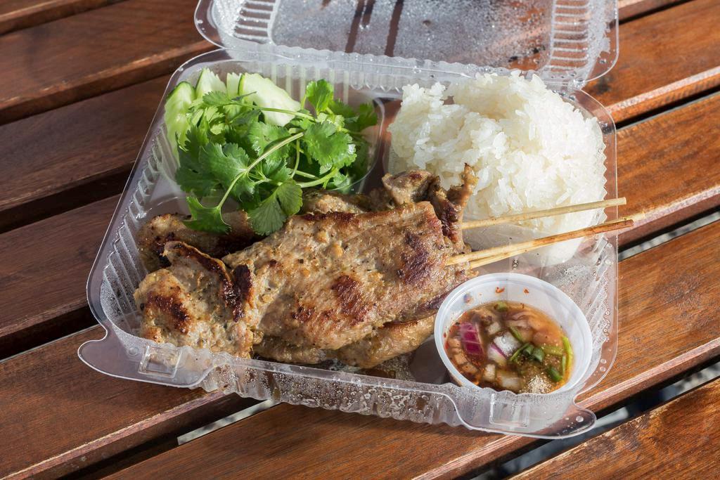 Grilled Pork Skewers 🌶 · Mild spicy. Marinated pork, seasoned and grilled to perfection on wood skewers. Served with fresh-made tamarind herb blend dipping sauce and sticky rice.
