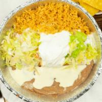Shredded Chicken Chimichanga · A large flour tortilla stuffed topped with cheese sauce and served with rice beans lettuce a...