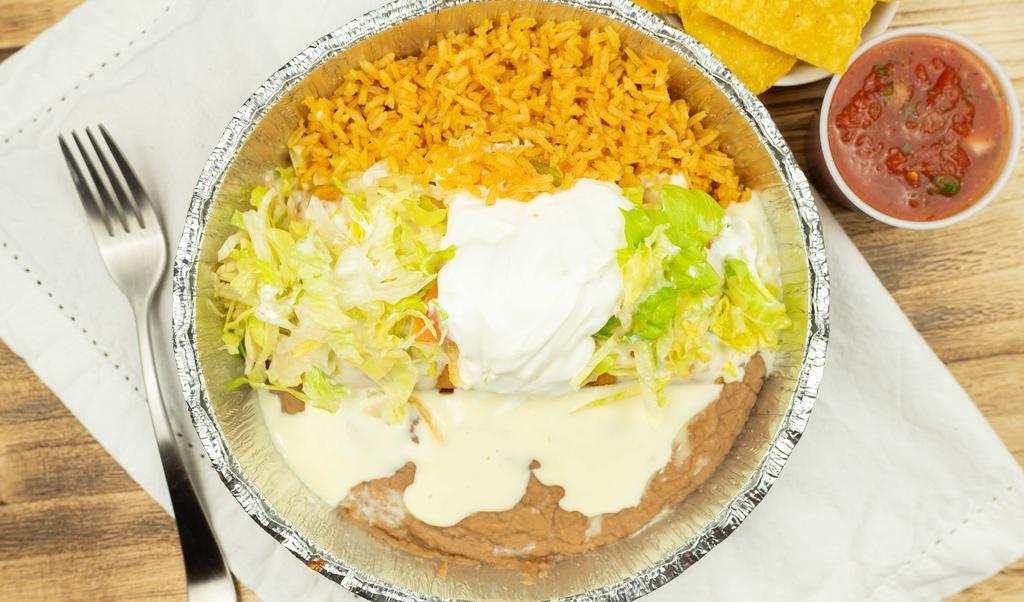 Shredded Chicken Chimichanga · A large flour tortilla stuffed topped with cheese sauce and served with rice beans lettuce and sour cream.