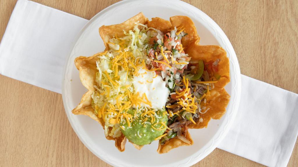 Taco Salad · Crunchy taco bowl served with beans, shredded beef mixed with onions, tomatoes and green bell peppers topped with lettuce, pico de gallo, sour cream, guacamole and cheese