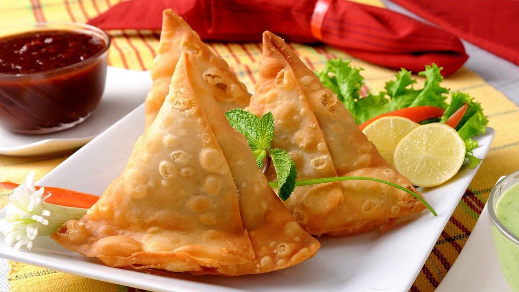 Vegetable Samose · Triangular pies stuffed with potatoes and peas, delicately tempered with spices and herbs.