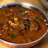 Goat Curry · Braised goat chunks with a gravy of browned onions, garlic, ginger and spices.