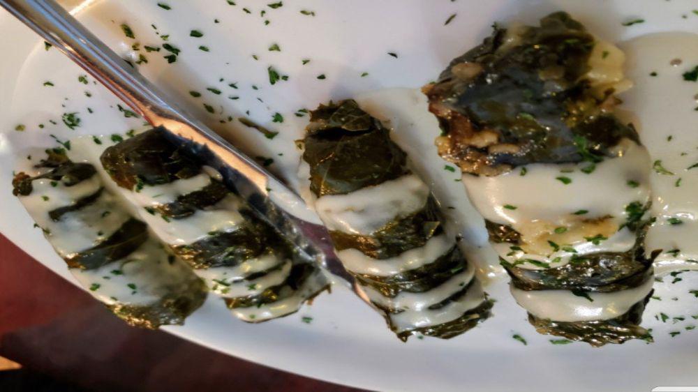 Vegetarian Grape Leaves · Handmade in our kitchen. Grape leaves, stuffed with rice, tomatoes, parsley and spices. Served warm with tahini sauce.