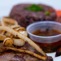 Bistec De Palomilla · Thinly sliced marinated sirloin steak with grilled onions served with moros and maduros.