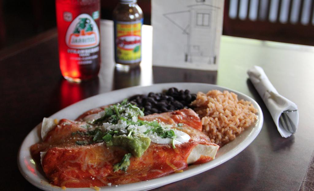 Enchiladas  · Made to order. Choice of meat in two enchiladas, topped with either green sweet and spicy tomatillo sauce, or traditional red enchilada sauce. Topped with melted cheese, crema, guacamole, pico. Served with a side of rice and black beans.