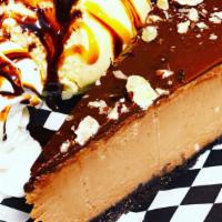 Nutella Cheesecake · Slice of nutella cheesecake with scoop of vanilla ice cream, whipped cream, chocolate and ca...