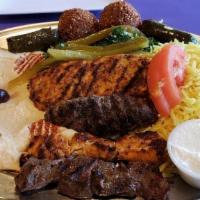 Phoenicia Combo · One grilled lamb or beef long patty, chicken cubes, two falafels two dolmades and tahini sau...