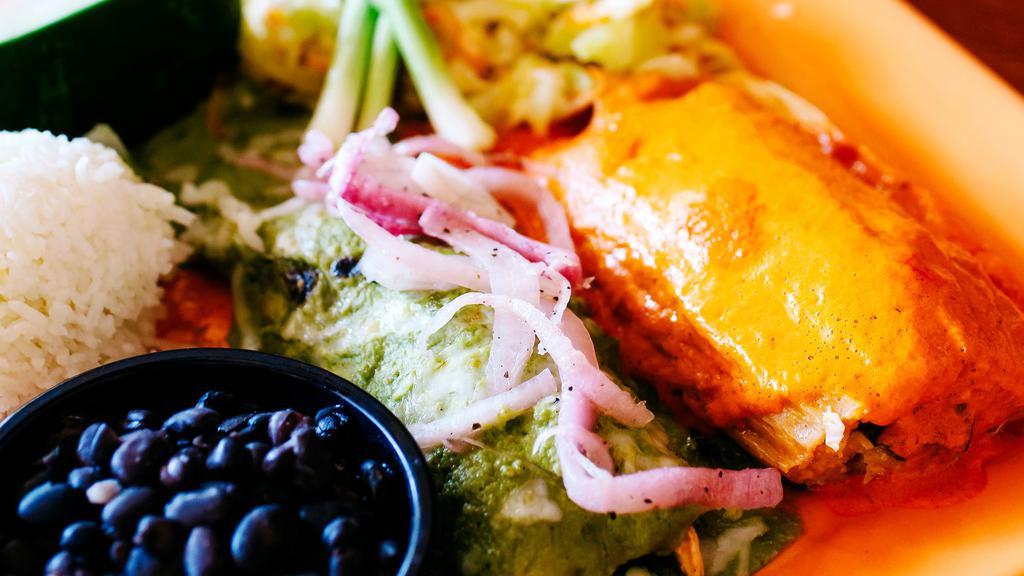 Enchiladas Yucatecas · Two rolled corn tortillas filled with shredded chicken, covered in a rich habanero cream sauce, melted jack cheese, red onion escabeche.