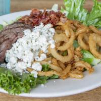 Grilled Steak Salad · Crisp greens topped with fresh grilled steak strips, bacon, bleu cheese crumbles, and tomato...