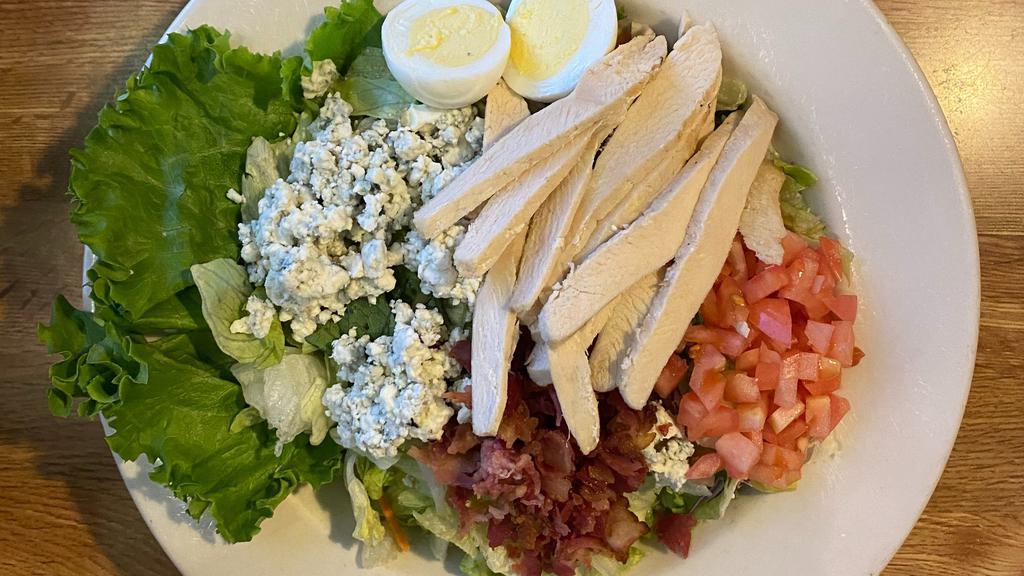 Cobb Salad · Crisp greens, tender grilled chicken breast bacon, tomatoes, crumbled bleu cheese, and a hard-boiled egg.