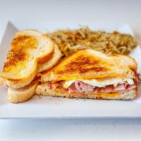 Sunrise Sandwich · Butter toasted sourdough, two over medium eggs, cured ham & American cheese with hash browns