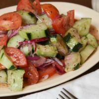 Cucumber Salad · Cucumbers, fresh tomatoes, red onions, black pepper, oregano, basil, olive oil and vinegar.