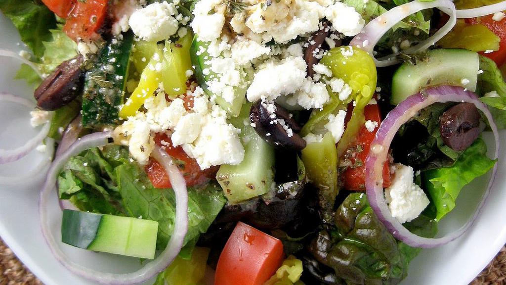 Greek Salad · Fresh crisp romaine lettuce, kalamata olives, tomato, cucumber, red onion, feta cheese and dolmas. Our house made italian is also our greek dressing. Choice of dressing is served on the side.