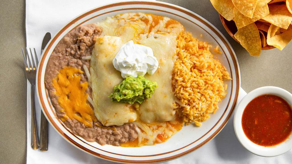 Enchiladas Rancheras · Two Corn Tortillas stuffed with Chicken or Shredded Beef covered with Sauce and Cheese, served with Rice and Beans, side of Guacamole and Sour Cream.