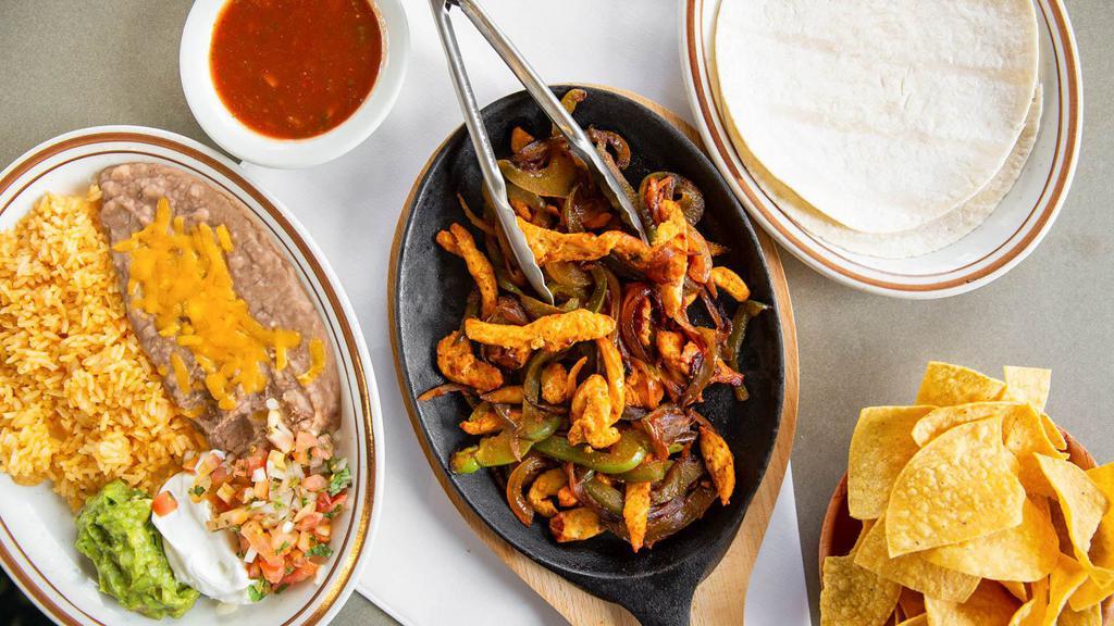 Fajitas · Marinated strips of Steak or Chicken sautéed with Green Peppers and Onions served with Rice and Beans side of Guacamole, Sour Cream, Pico de Gallo and Tortillas.