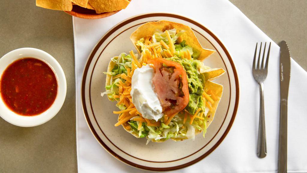 Taco Salad · Tortilla Shell filled with Chicken or Shredded Beef, Beans, Cheese and Lettuce, side of Guacamole Sour Cream and Tomatoes.