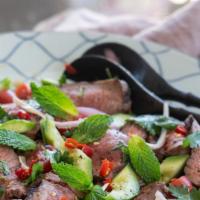 Beef Salad · Tender slices of grilled beef tossed in tomatoes, red onions, green onions, mint, cilantro, ...
