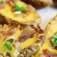 Potato Skins (5) · Loaded with Cheddar and baked with bacon and chives.