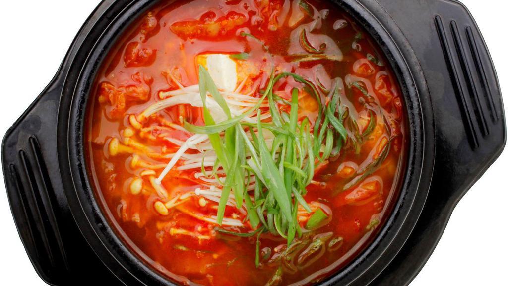 Kimchi Jjigae (Kimchi Stew) · A spicy, hearty kimchi stew with pork, tofu, enoki-mushrooms and scallions. Served with side dishes.