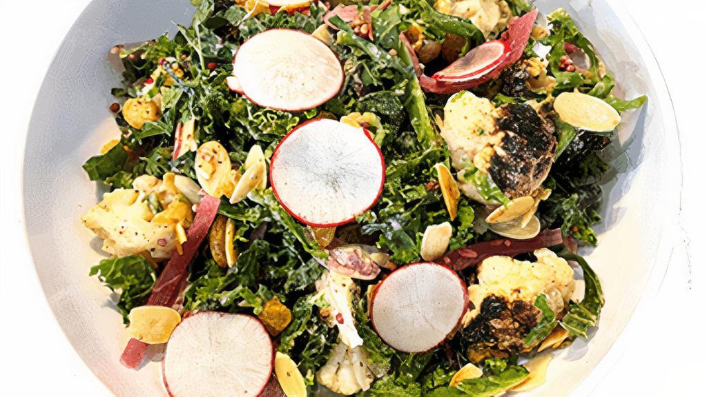 Shaved Kale Salad (Delivery) · Shaved kale with roasted cauliflower, golden raisins, pickled onions, toasted almonds, radish and tahini dressing.