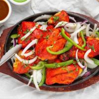 Tandoori Chicken · Bone-in chicken legs flavored with yogurt and spices and then roasted. Served on a sizzling ...