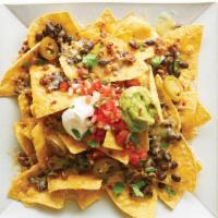 Loaded Nachos · Crispy tortilla chips loaded with melty baked cheese, rice, beans, and your choice of protei...