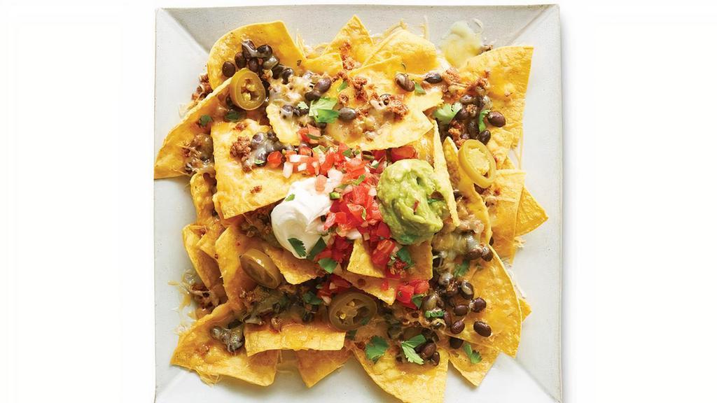 Loaded Nachos · Crispy tortilla chips loaded with melty baked cheese, rice, beans, and your choice of protein, salsa, and toppings.
