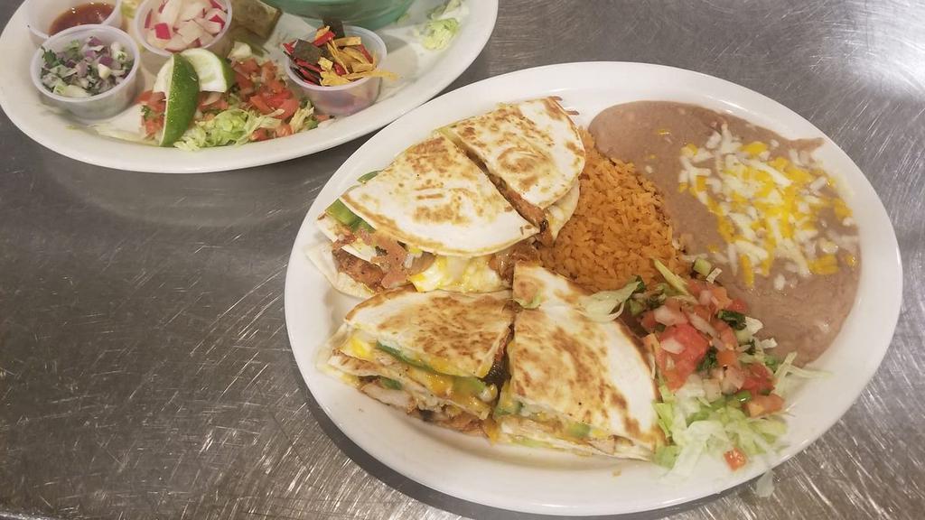 Fajita Quesadilla · A grilled flour tortilla stuffed with cheese, peppers, onions and mushrooms grilled with your choice of fajita grilled chicken, Portobello mushrooms or carnitas. Served with refried beans and rice.