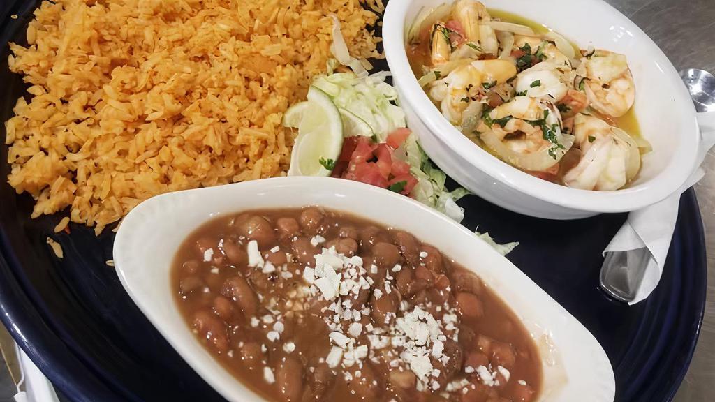 Camarones Al Mojo De Ajo · Shrimp grilled in butter, lemon and garlic and topped with diced tomato, onion and cilantro.  Served with rice, beans and warm tortillas.