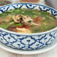 Tom Yum / ต้มย่า · Hot and sour soup with mushroom, cilantro, lime leaves, and lime juice.