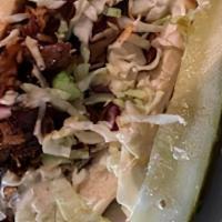 Bbq Pulled Pork · Gluten-free. Marinated shredded pork smothered in BBQ sauce, topped with coleslaw and a pick...