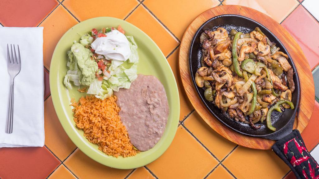 Fajitas (Chicken, Beef Or Combination) · served with rice, refried beans, salad, guacamole, sour cream and tortillas. fajitas are prepared bell peppers, onion and mushrooms. choose, beef or chicken or combo.