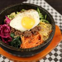 Hot Stone Bibimbop · An assortment of vegetables with your choice of meat and sauce with a fried egg on top of st...