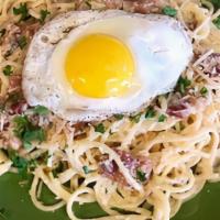 Bacon And Egg Carbonara · Piping hot pasta tossed in a garlic cream sauce with fresh bacon. Topped with a sunny side u...