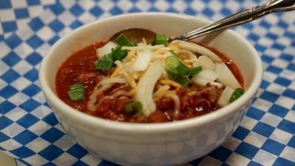 Homemade Chili · A bowl of our house-made chili, topped with cheese and onion. Served with delicious Yummy! garlic toast.