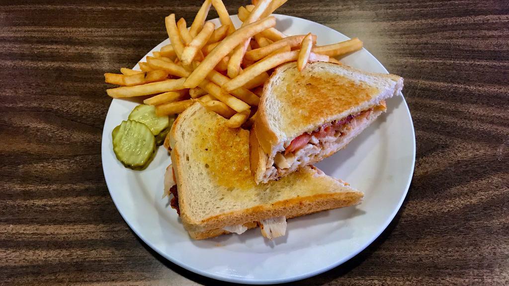 Turkey Melt · Turkey with bacon, tomato and cheddar cheese, served on grilled sourdough. Served with French fries.