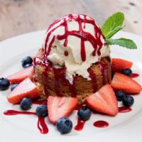 Warm Butter Cake · Topped with french vanilla ice cream, raspberry sauce, fresh strawberries, and blueberries.