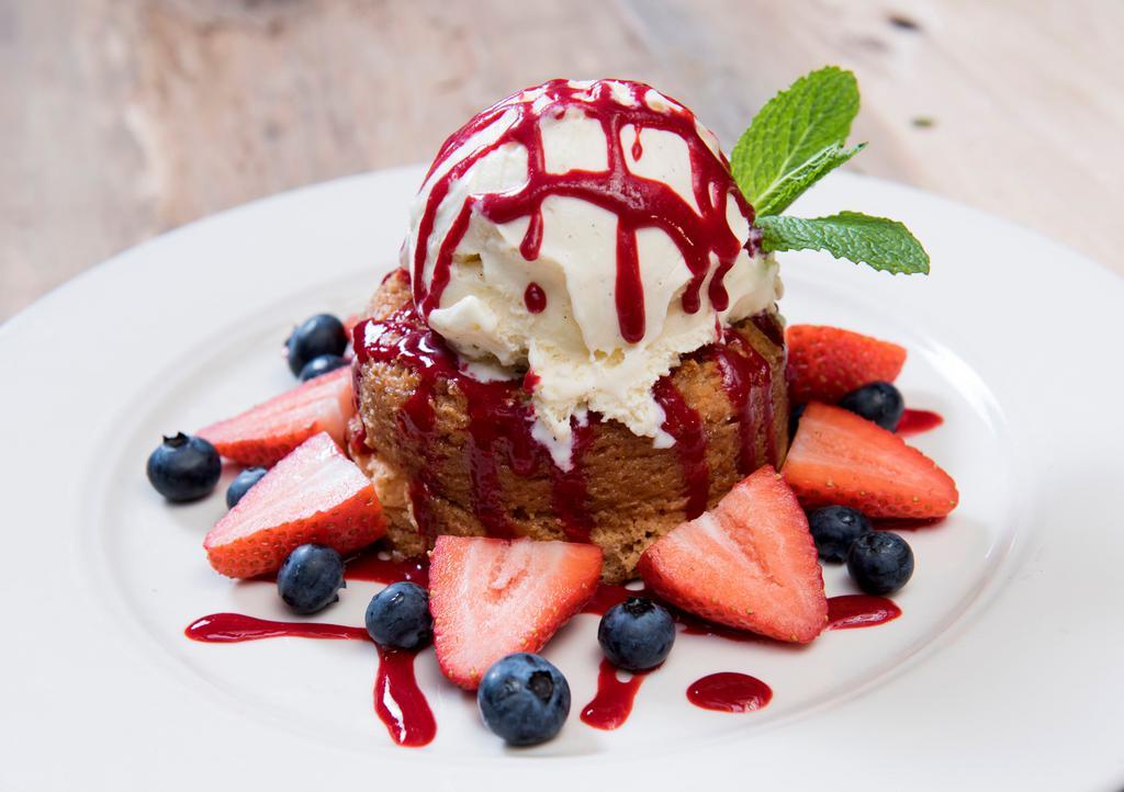 Warm Butter Cake · Topped with french vanilla ice cream, raspberry sauce, fresh strawberries, and blueberries.