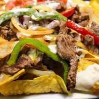 Fajita Nachos · Made with Fresh homemade corn tortilla chips, cheese, refried beans, and your choice of Stea...