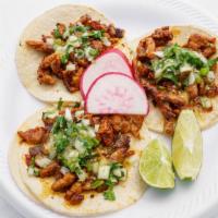 Tacos Al Pastor · Pork loin grilled in a special sauce and flame-broiled. Sliced folded into three soft corn t...