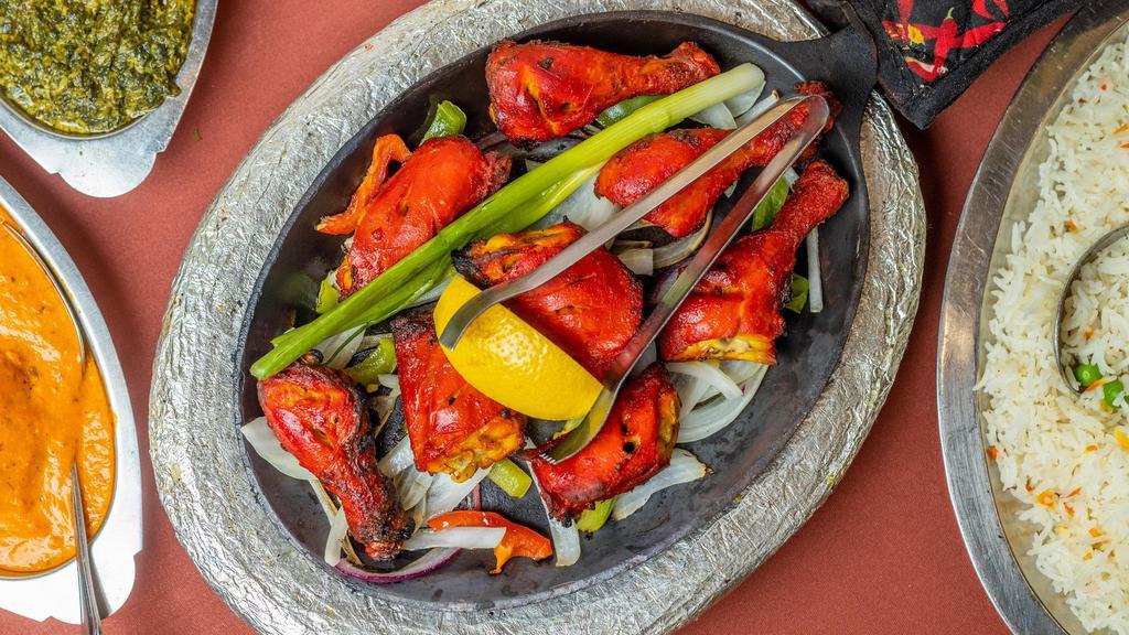 Tandoori Murg · One half chicken marinated overnight in yogurt and spices; barbecued in a traditional clay oven.