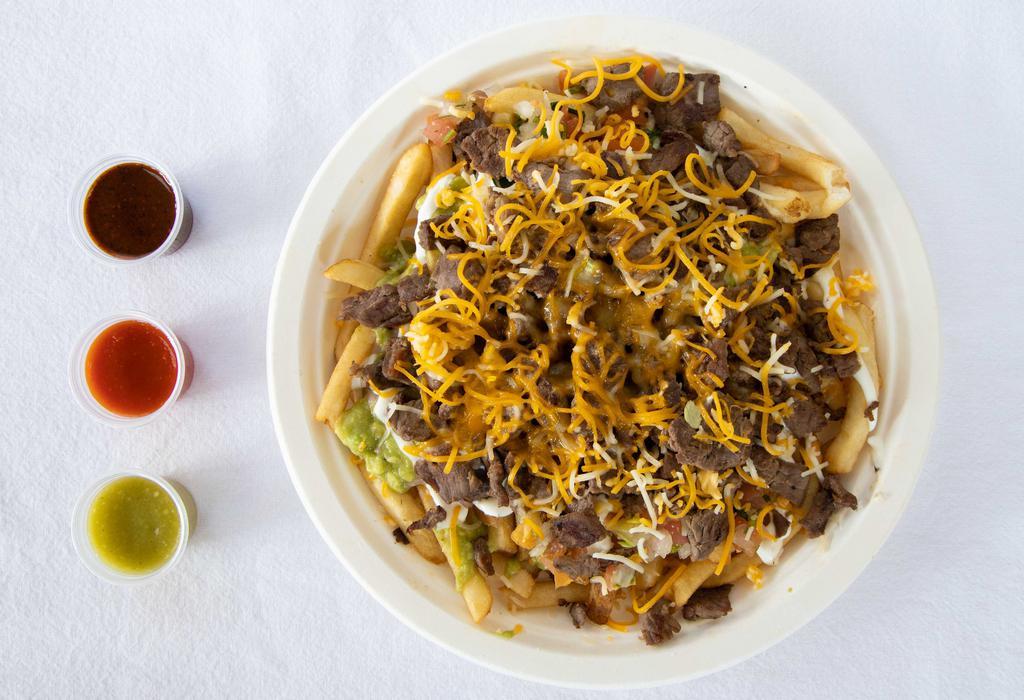 Carne Asada Fries · Made with french fries, steak, guacamole, pico de gallo, sour cream, beans, and cheddar cheese.